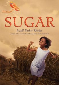 The book cover for Sugar by Jewell Parker Rhodes, shows a young African American girl in a simple white dress running in a field on a gloomy day, looking back at an orange kite she is flying high